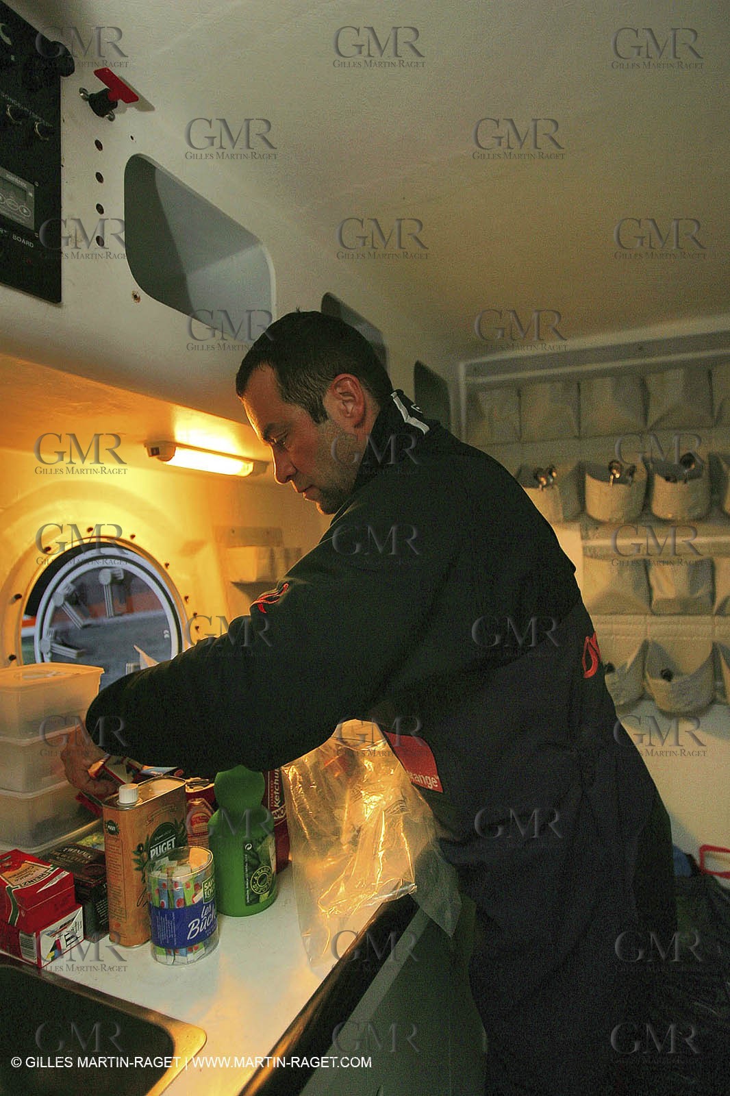 Orange II - Jules Verne Trophy 2004 - Jean-Baptiste Epron preparing food in the galley