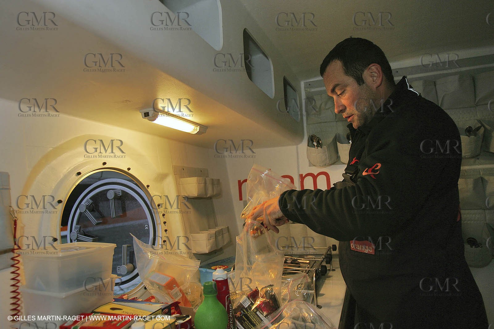 Orange II - Jules Verne Trophy 2004 - Jean-Baptiste Epron preparing food in the galley