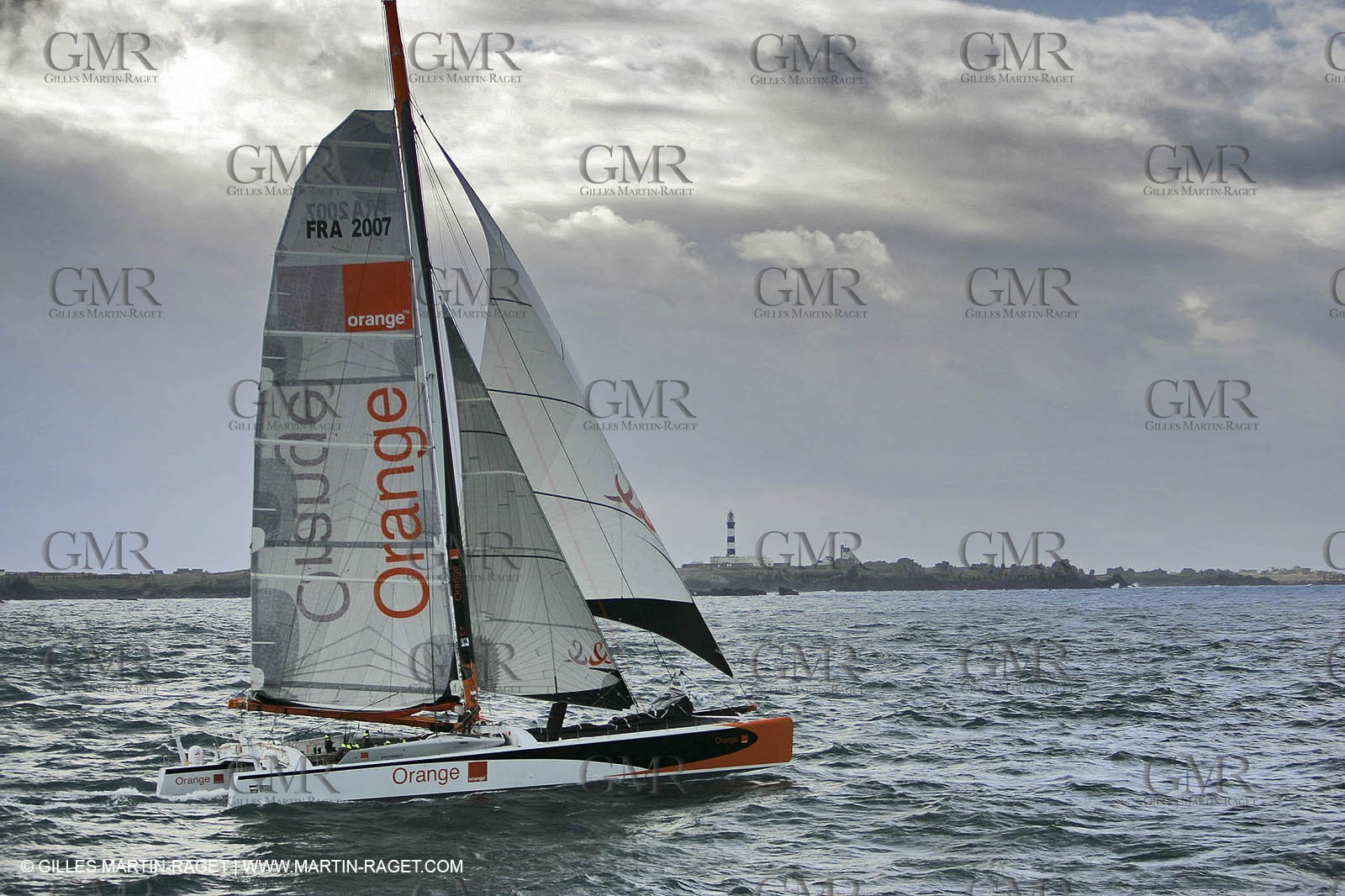 Orange II-2005 Jules Verne Trophy-Orange II and Bruno Peyron cross the starting line in front of the Ushant ligthhouse